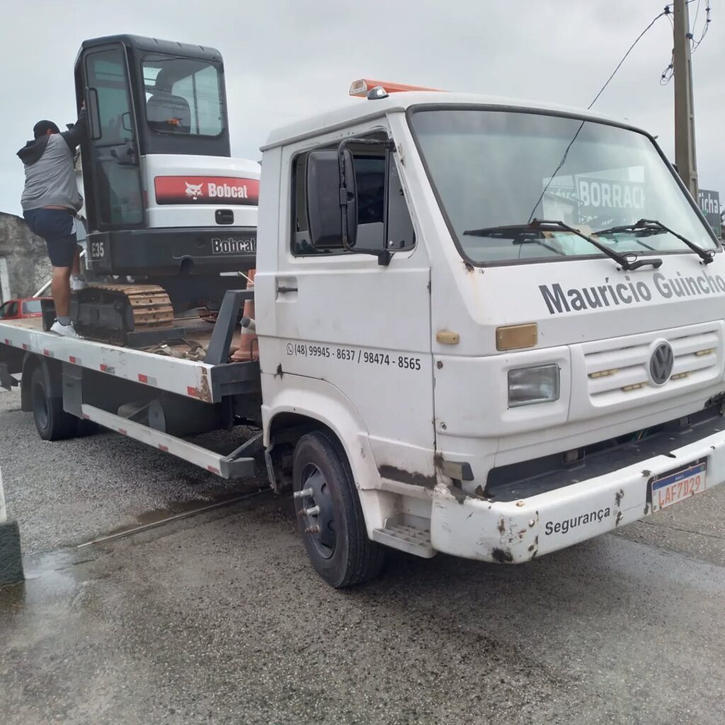 Mauricio Guincho com uma máquina de médio porte em cima do caminhão